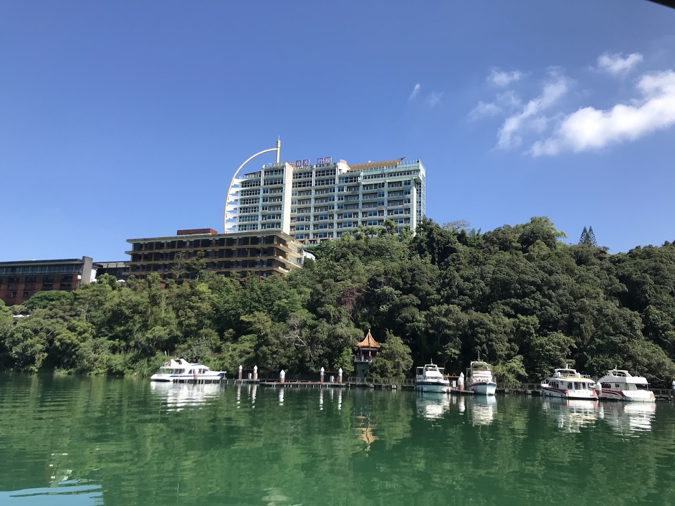 湖邊高樓飯店與多艘遊艇停靠的景色