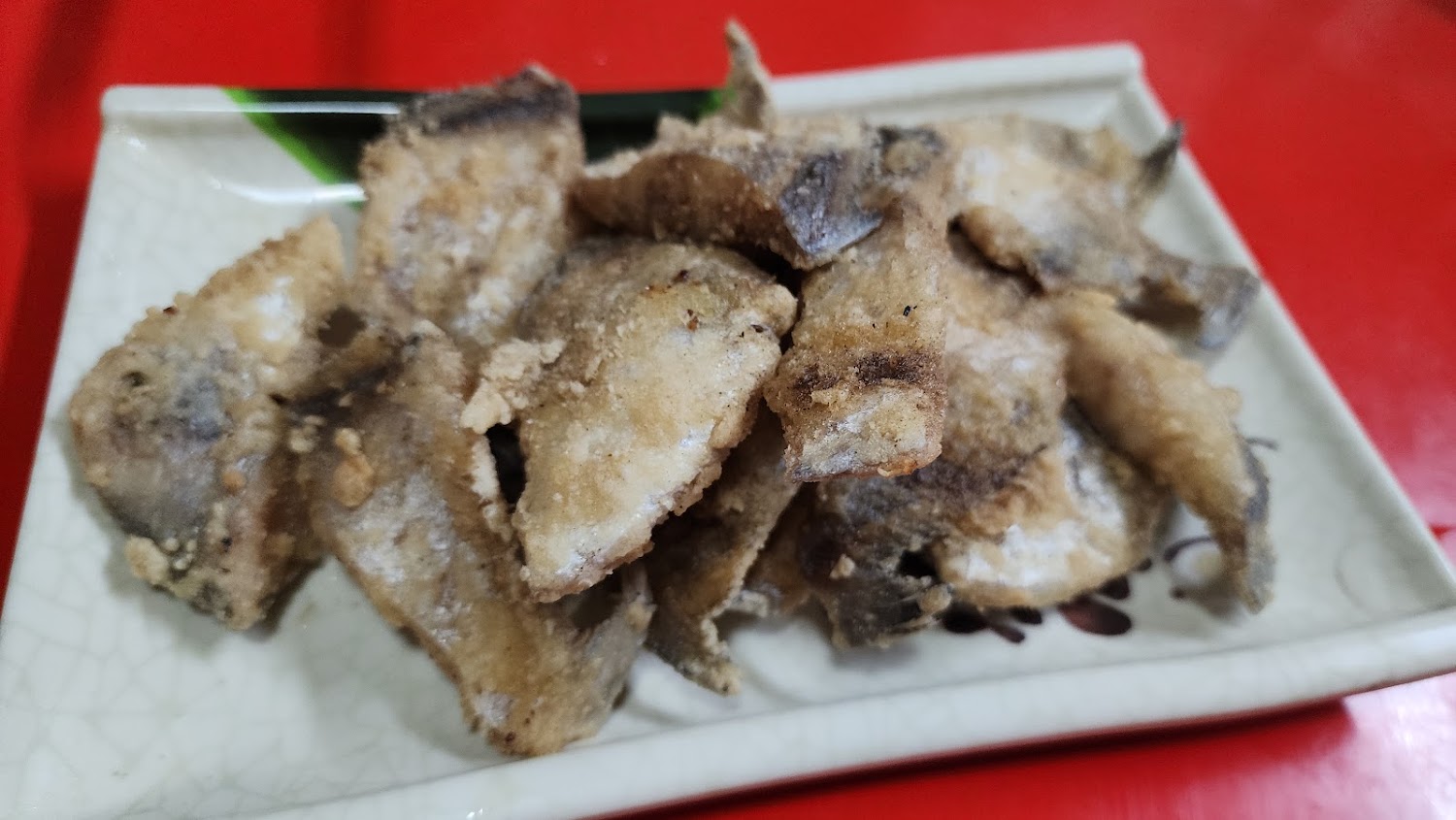 酥炸小魚片外皮金黃酥脆，盛裝在長盤上