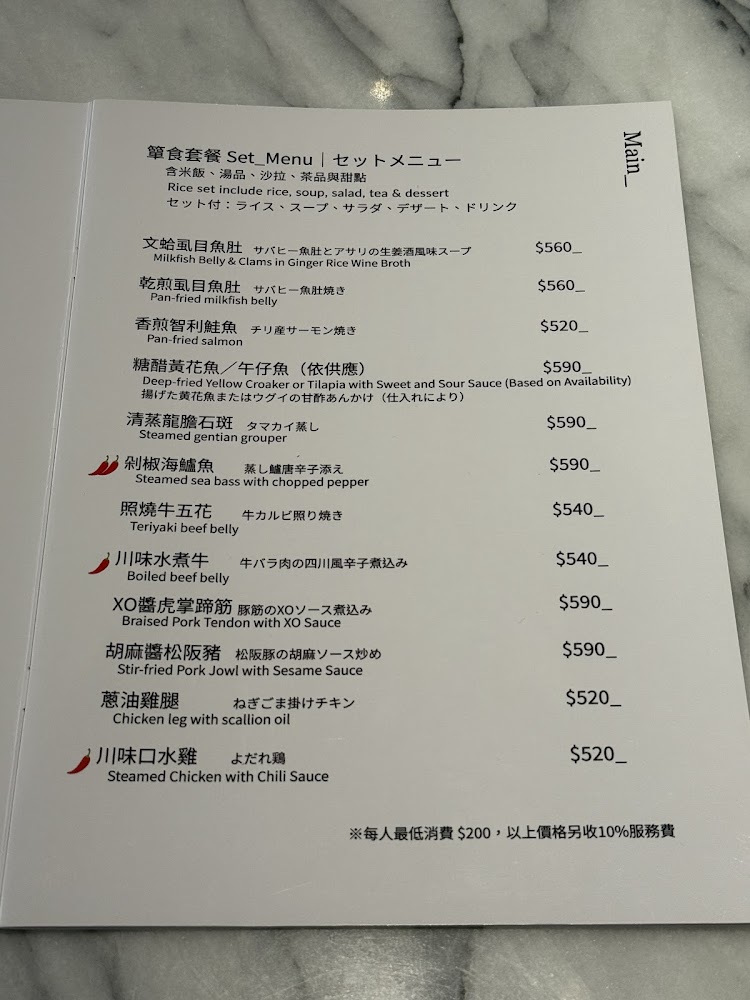 這是一張餐廳的套餐主菜菜單，包含各式魚、牛、雞、豬等料理，提供中、英、日三語描述，每道菜標示價格，並有辣味標示和最低消費等說明。