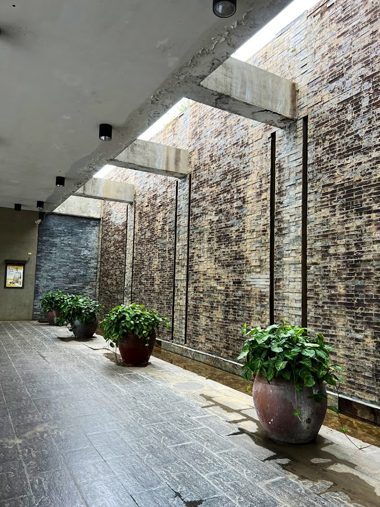長廊左側大型陶盆植栽右側石磚牆