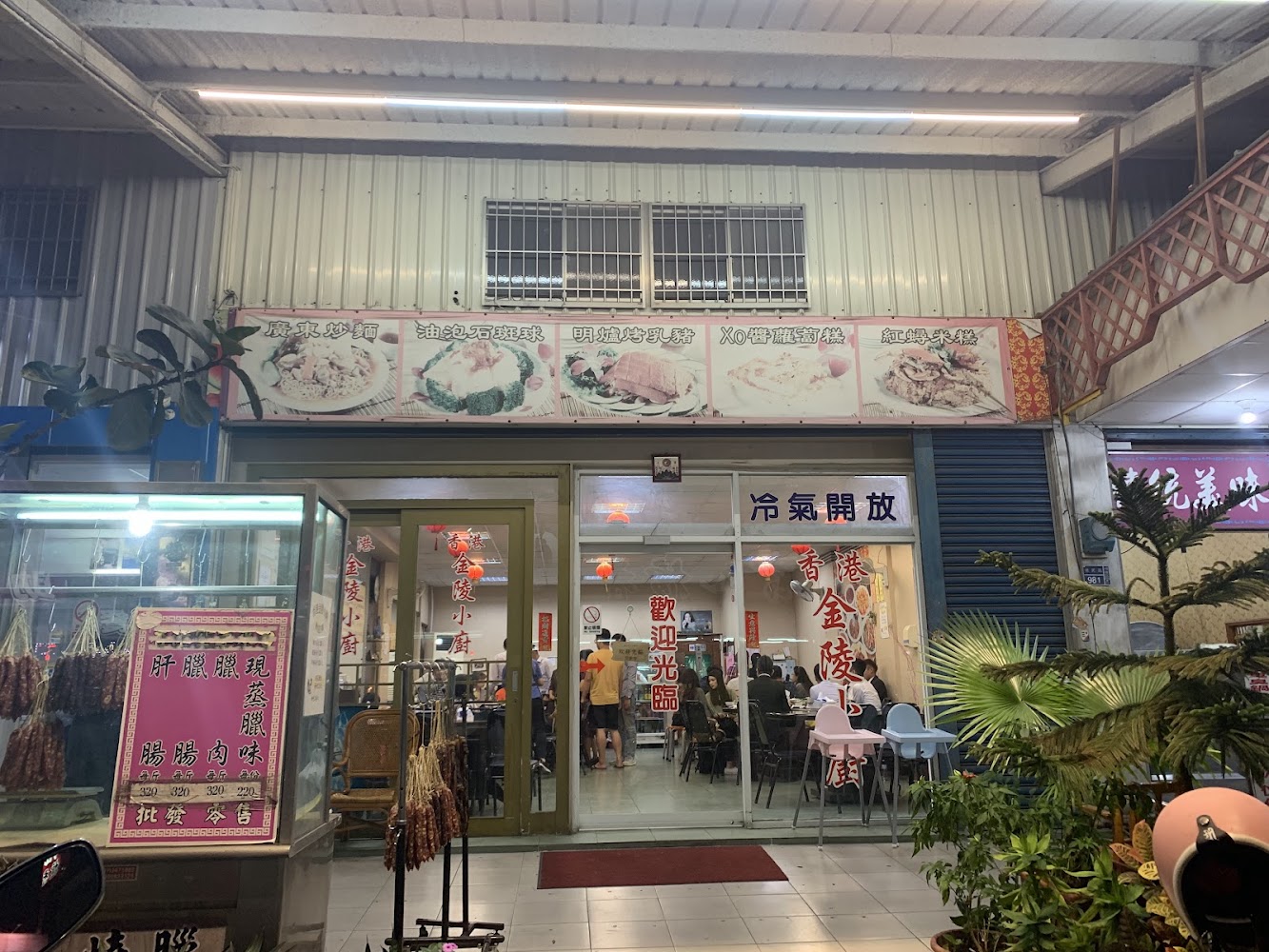 香港金陵小廚門口，店內燈光明亮，有招牌與臘味展示