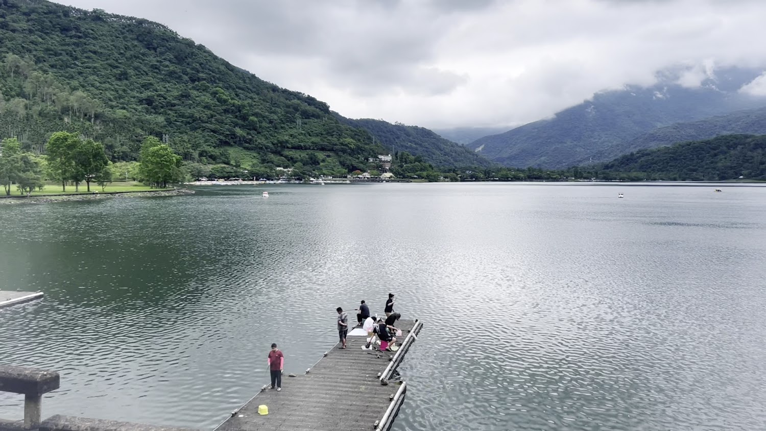 湖邊碼頭上有人休息與釣魚的悠閒景象