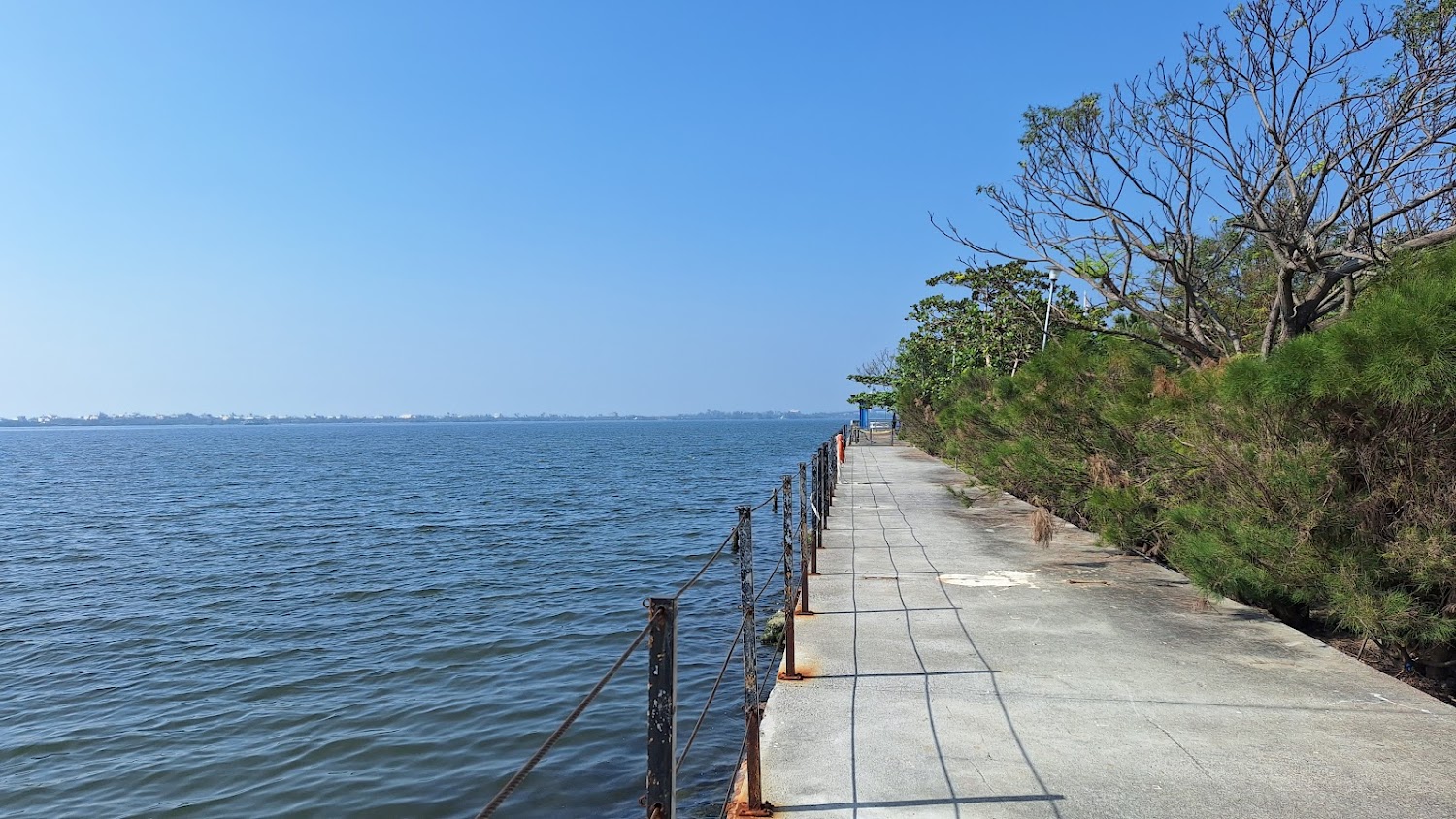 沿著水邊延伸的人行步道與藍天