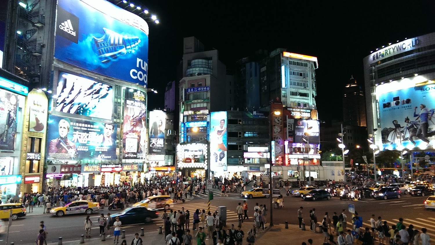 夜晚大樓外牆大型廣告看板與熱鬧人車
