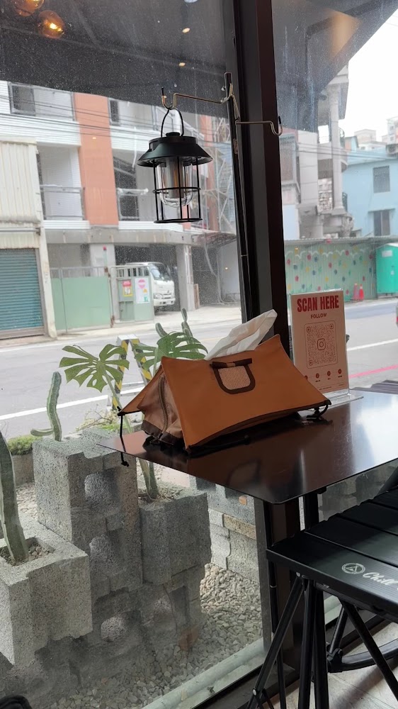 有大型玻璃窗的咖啡廳，桌上有寵物袋與QR碼牌