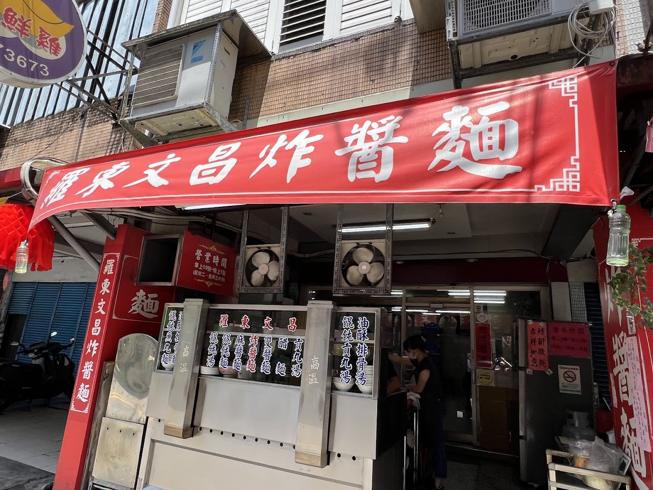 羅東文昌炸醬麵店門口，有紅色招牌和多個菜單