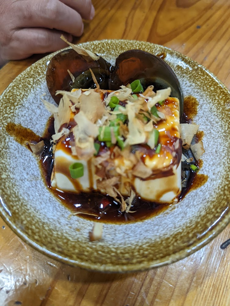 皮蛋豆腐淋上醬油並撒上蔥花與柴魚片