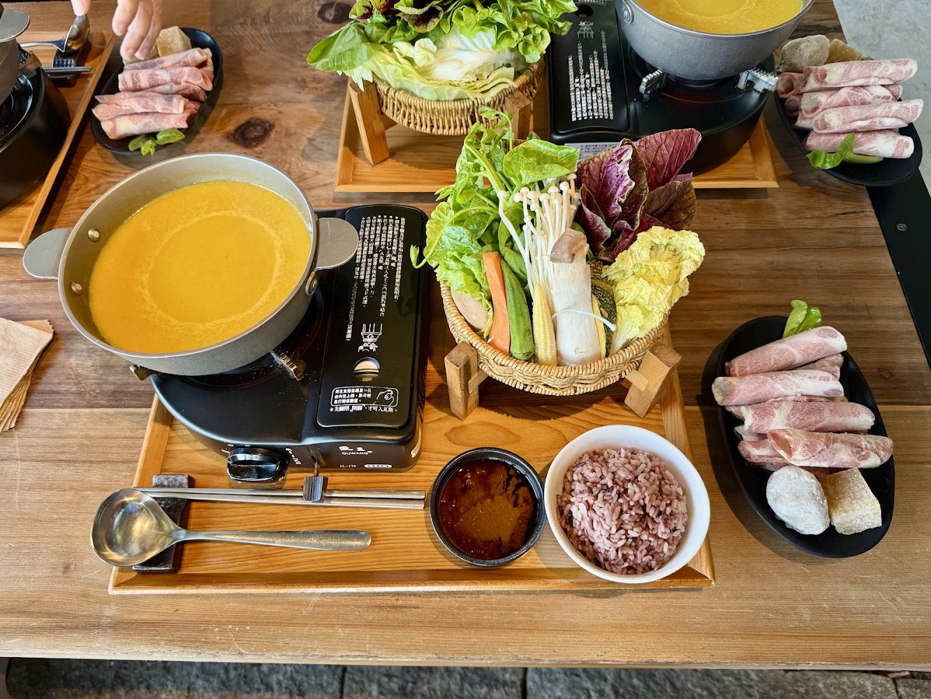 火鍋餐有湯底、多樣蔬菜拼盤、紅藜飯、醬料及肉片