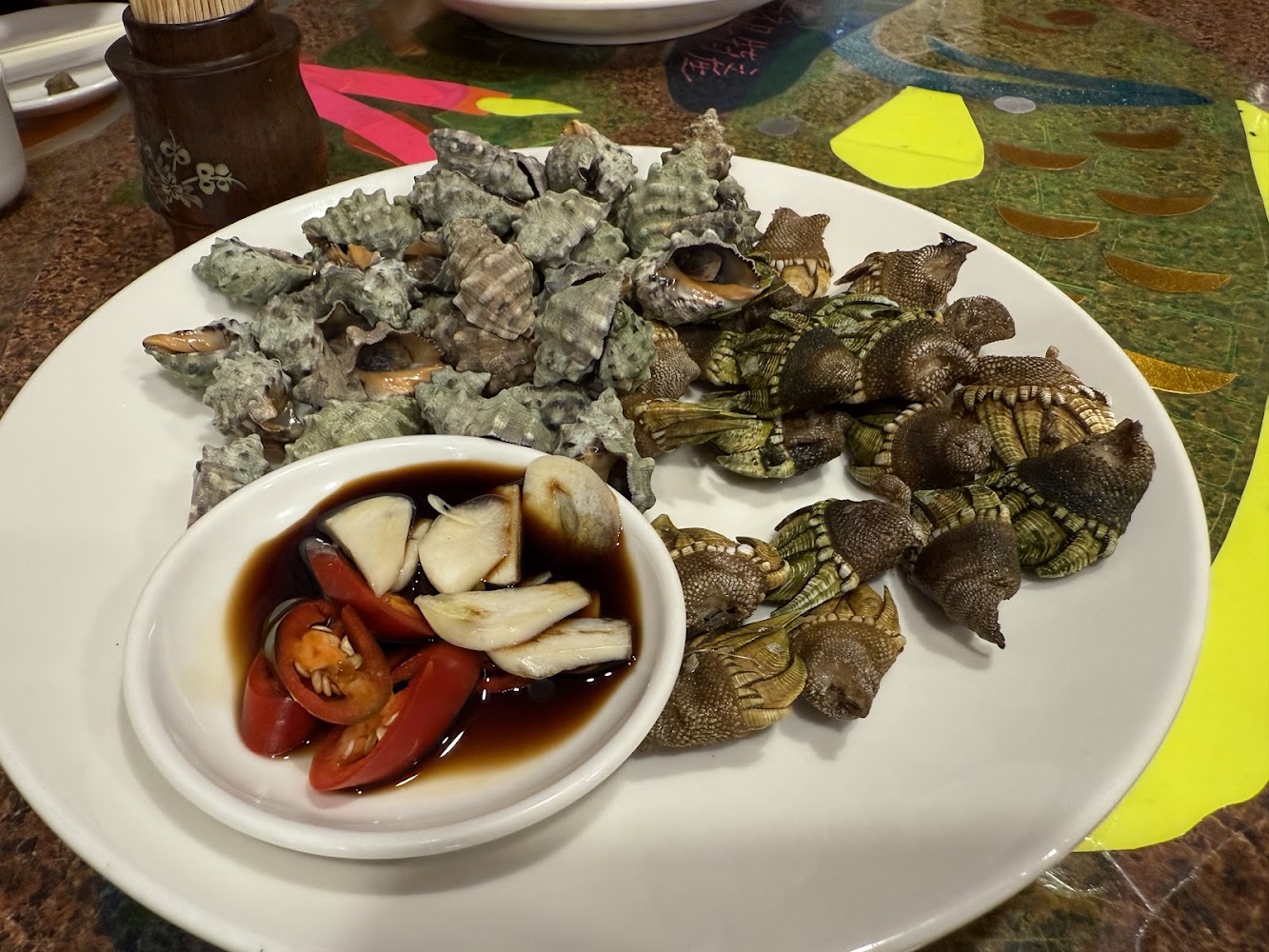 依嬤的店一盤海鮮，有海螺與鵝頸藤壺，旁邊附醬油蒜頭辣椒沾料