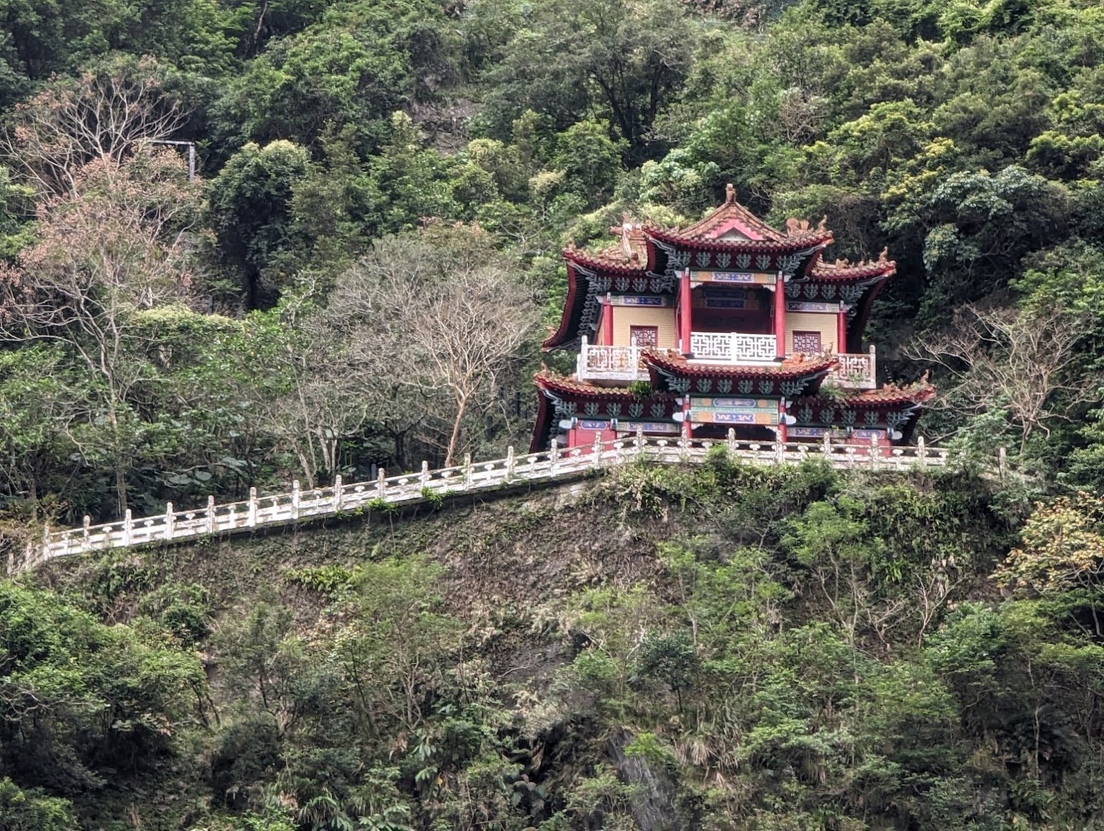 長春祠亭閣遠拍傳統宮廟建築掩映翠綠山壁白色欄杆太魯閣
