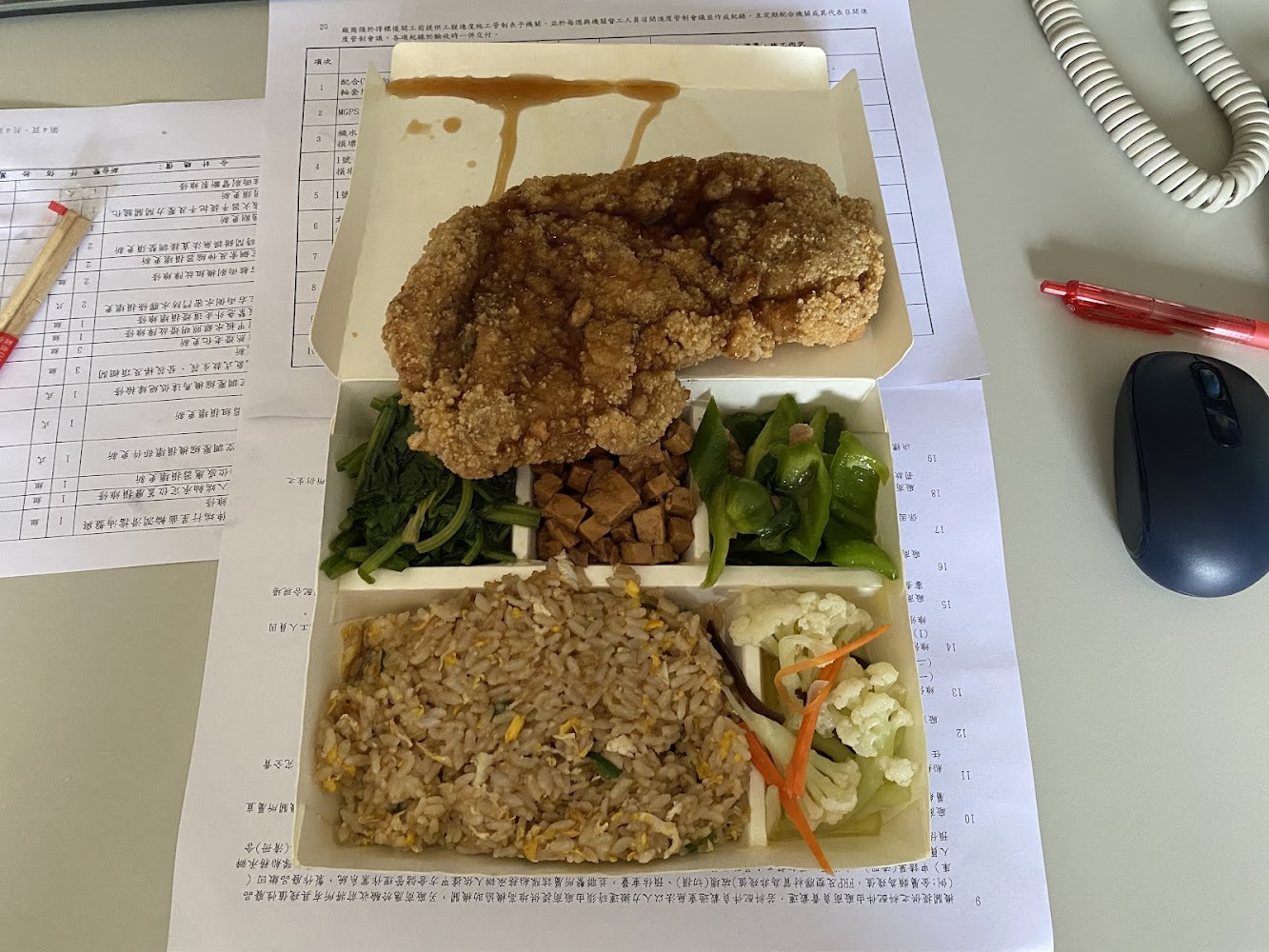 翊芳小館辦公桌上的炸雞排便當