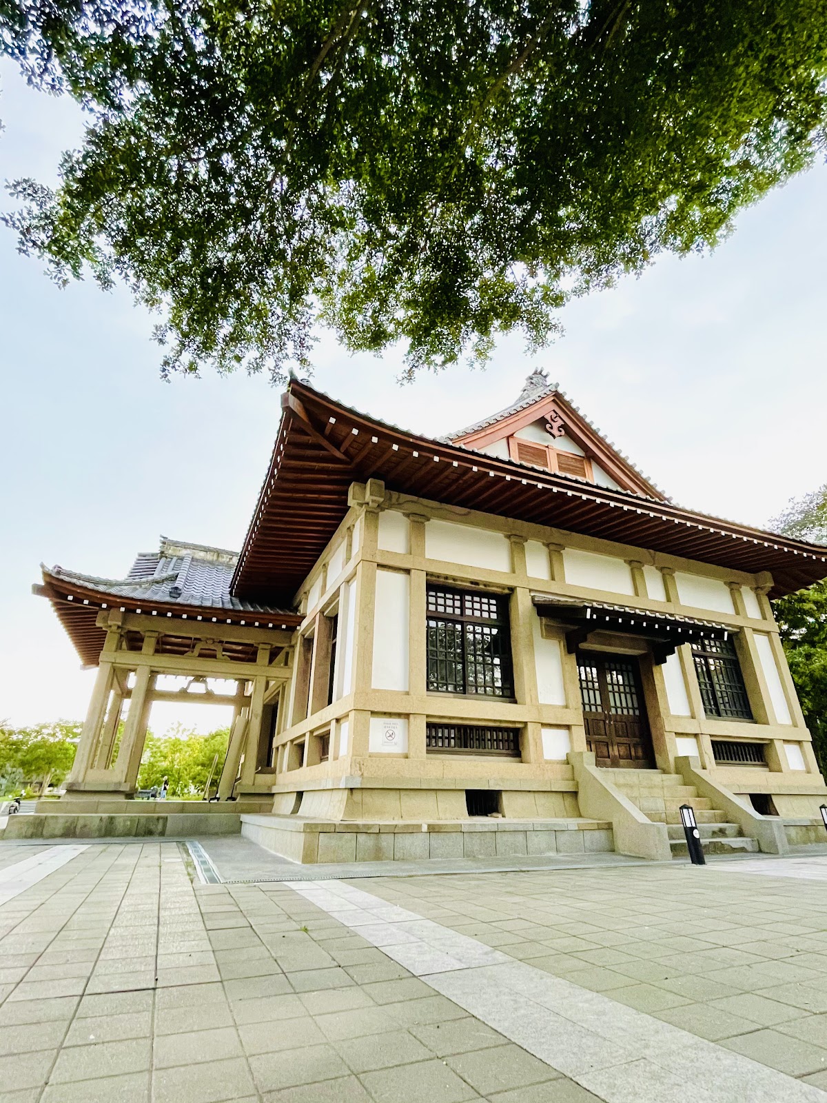 旗山武德殿日式建築低角度仰拍，米白色建築搭配紅色屋頂木造鳥居