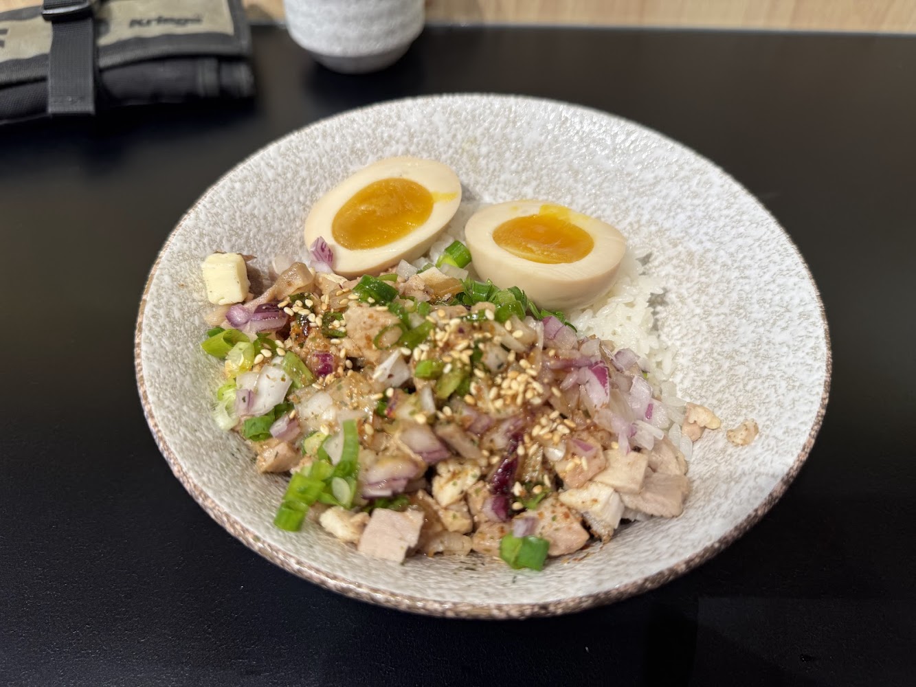 清流房日式拉麵雞肉飯，上有雞肉丁、洋蔥、芝麻與溏心蛋
