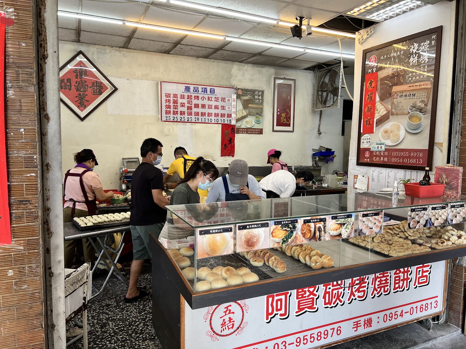 五結阿賢碳烤燒餅店店內全景，員工忙碌備料製餡