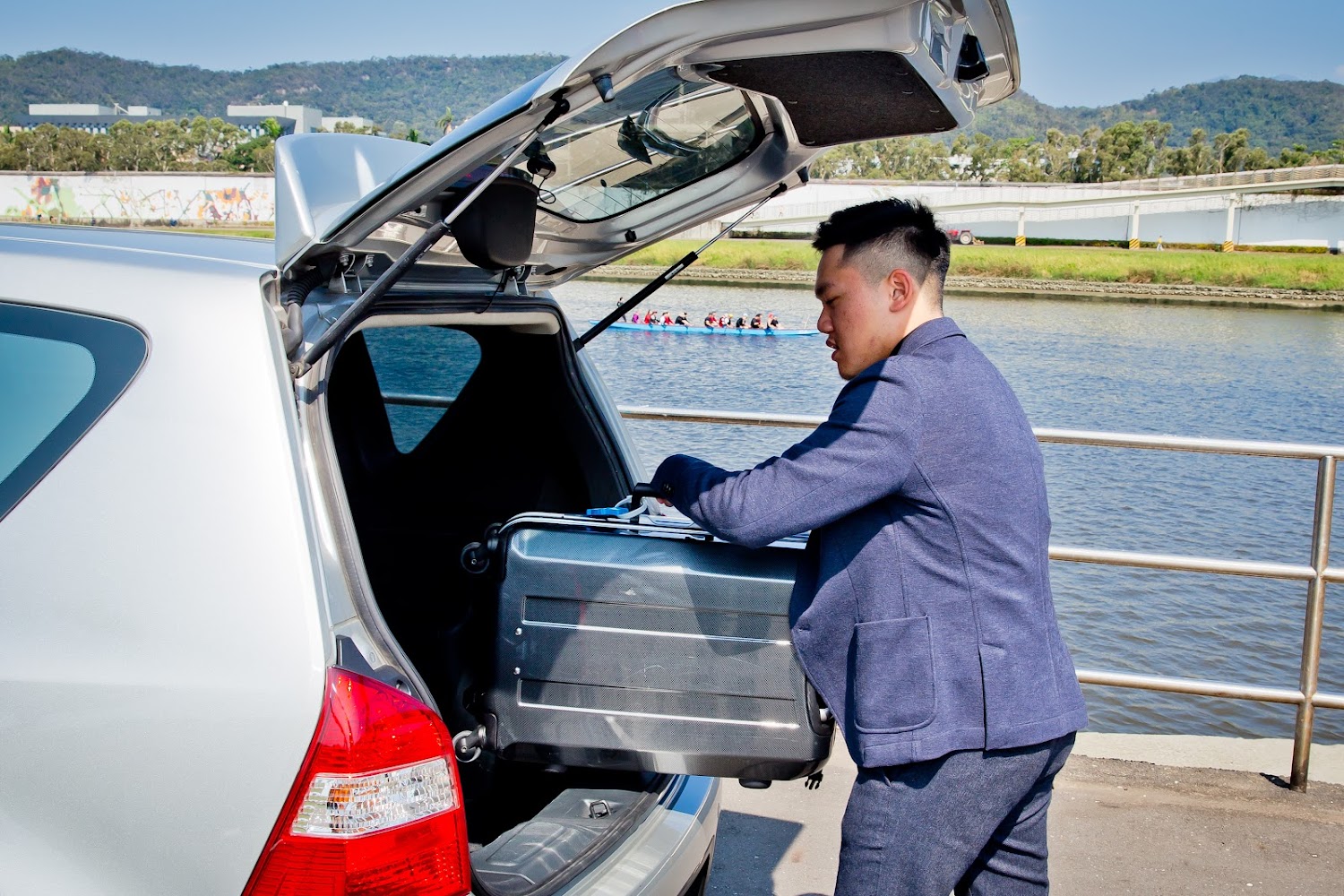 司機在河邊協助旅客搬運行李上車
