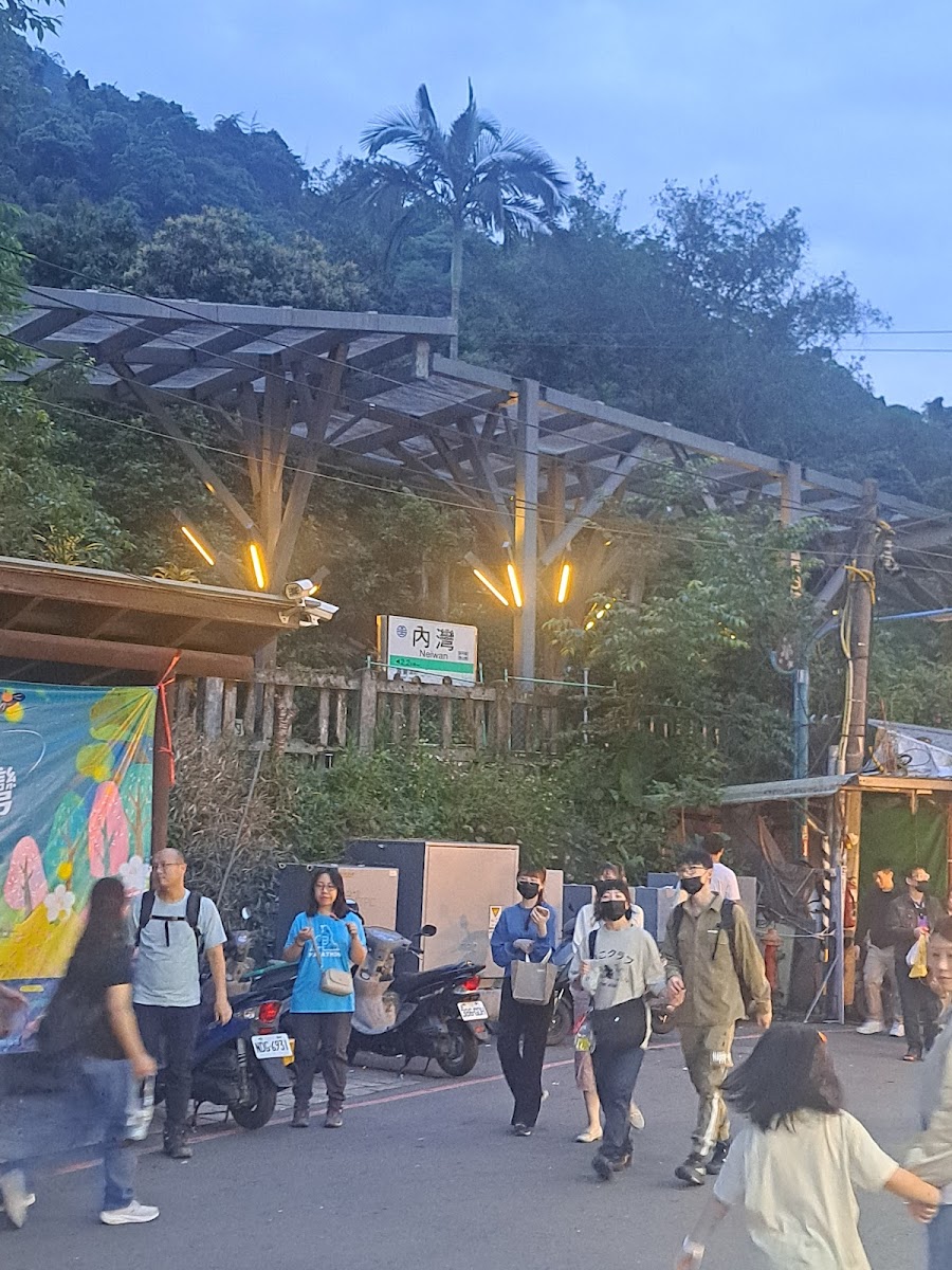 內灣火車站出口黃昏景，遊客熙攘，「內灣」站牌清晰可見