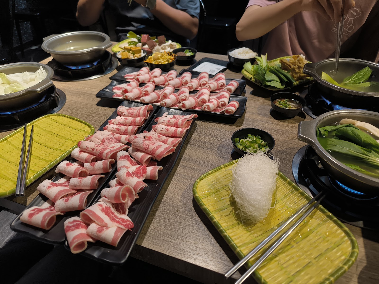 誠石火鍋西螺店大量捲好的肉片盤整齊排列，旁邊有鍋底