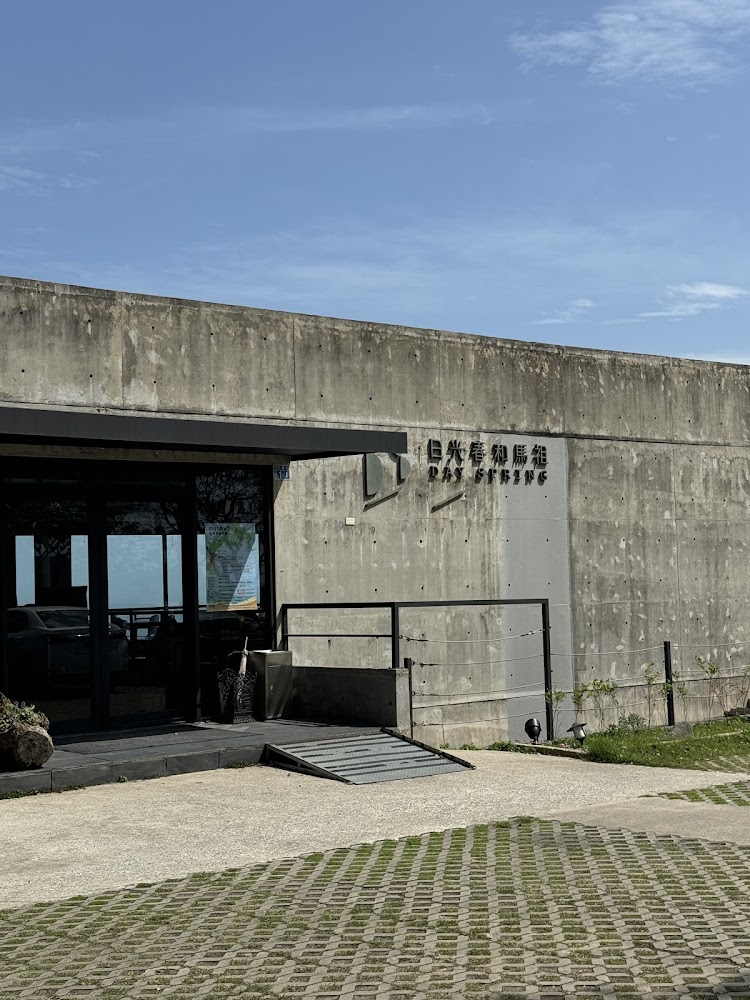 混凝土建築門口有無障礙坡道，牆上寫有日光春和馬祖 DAYSPRING