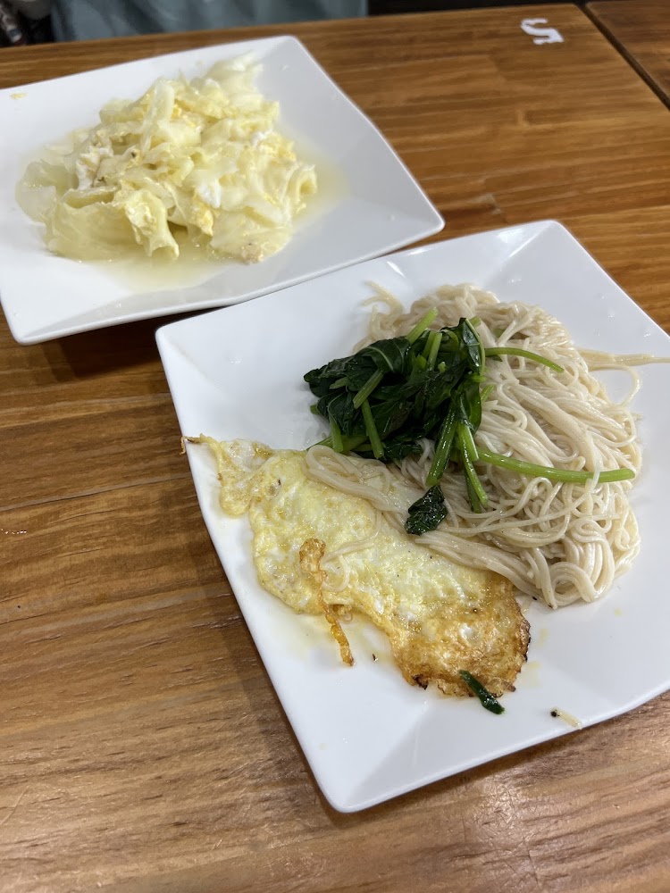 兩盤中式餐點，一盤是炒蛋高麗菜，另一盤是麵條搭配煎蛋及青菜