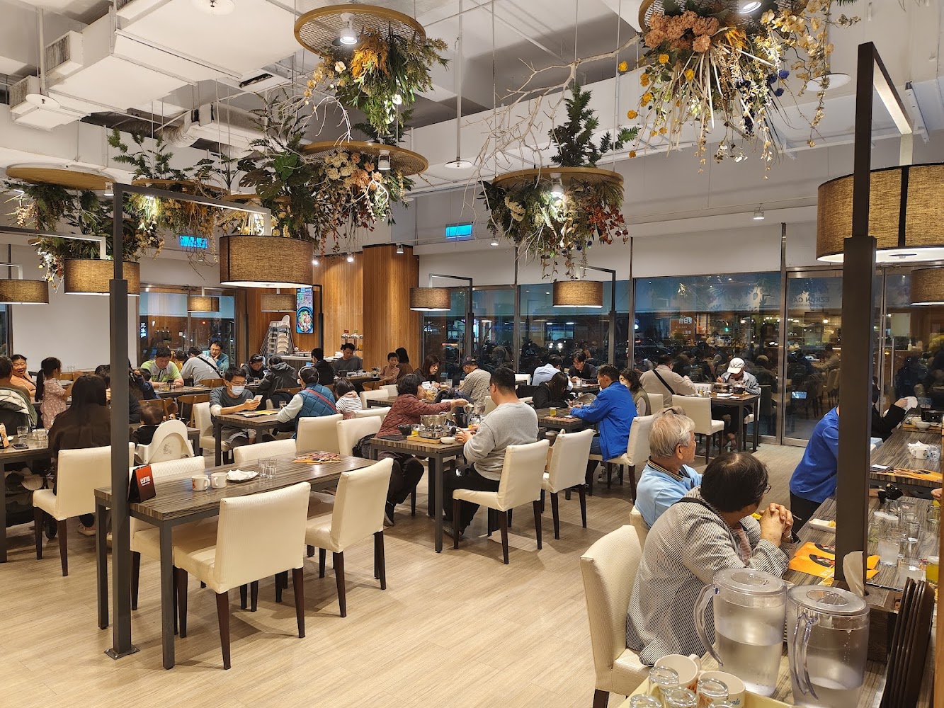現代明亮餐廳內有許多顧客正在用餐，氣氛熱鬧舒適