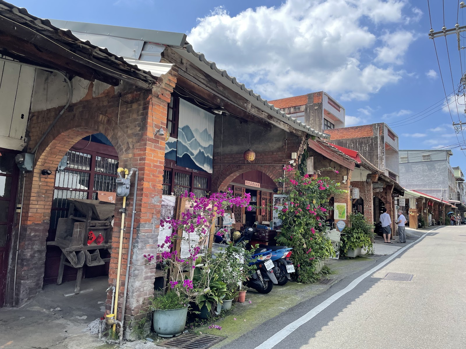 內灣老街白天拱廊建築，紅磚拱門，九重葛盛開，藍天白雲