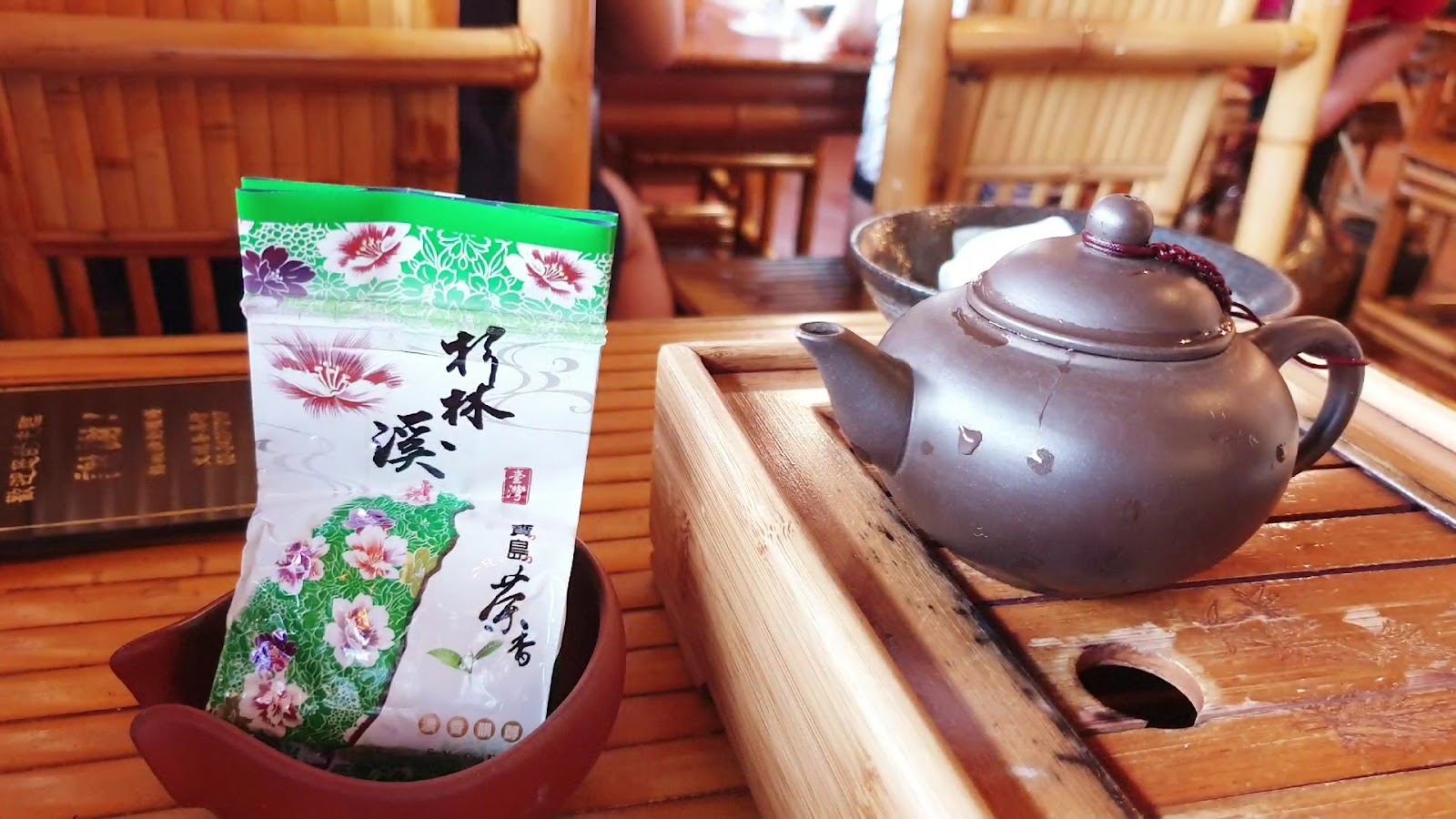 阿妹茶樓茶葉包裝展示，茶壺與竹製茶桌