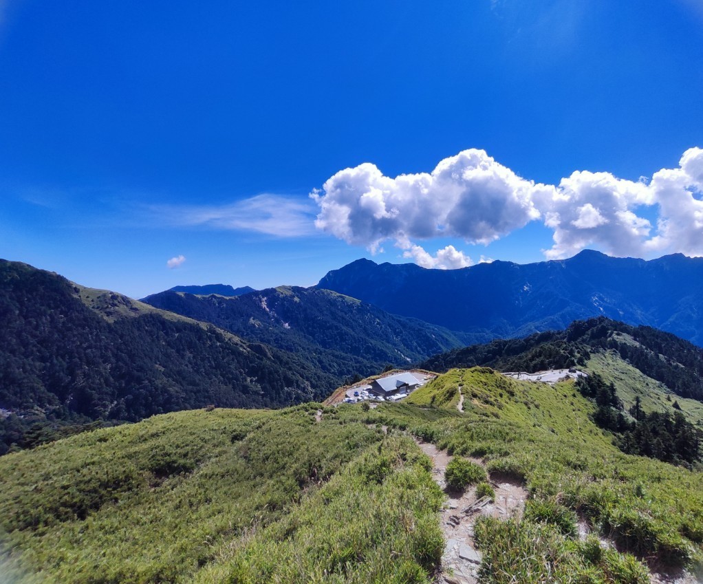 高山草原步道與遠方山巒屋舍