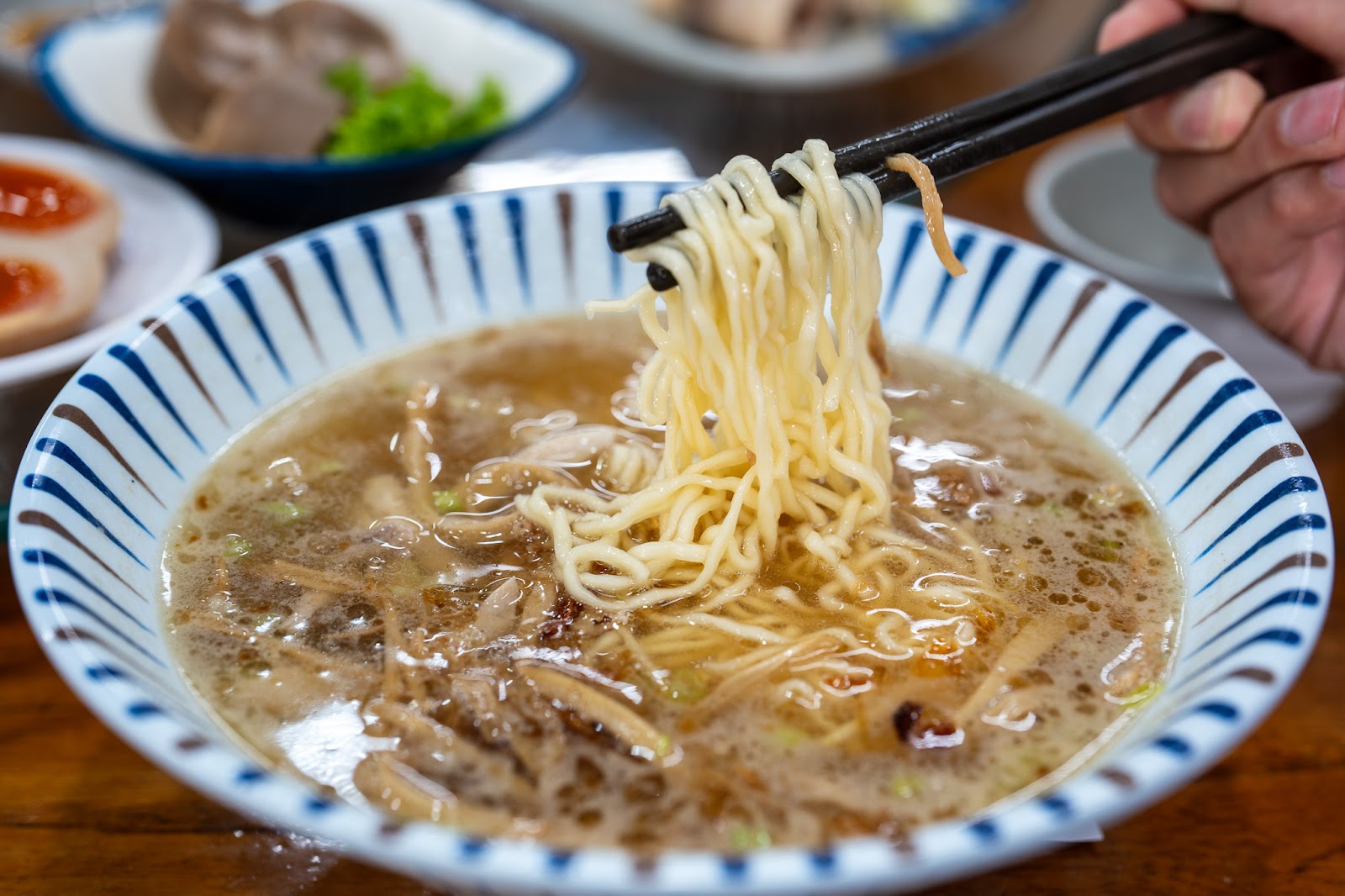 十一街大滷麵，藍白條紋碗，筷子夾起Q彈麵條，湯色濃郁