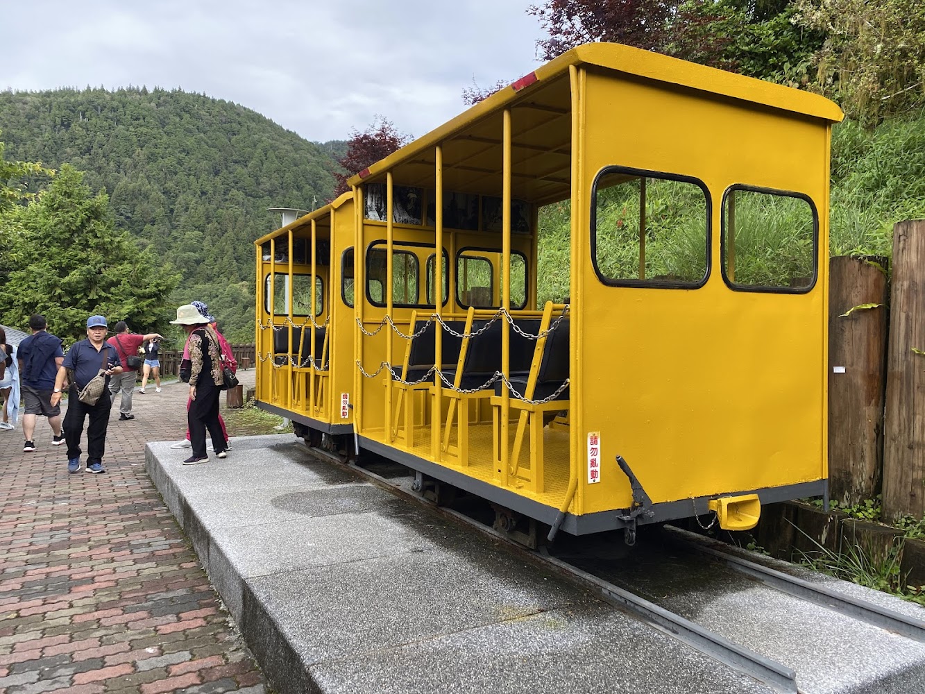 鮮黃色觀光小火車停放在鐵軌旁