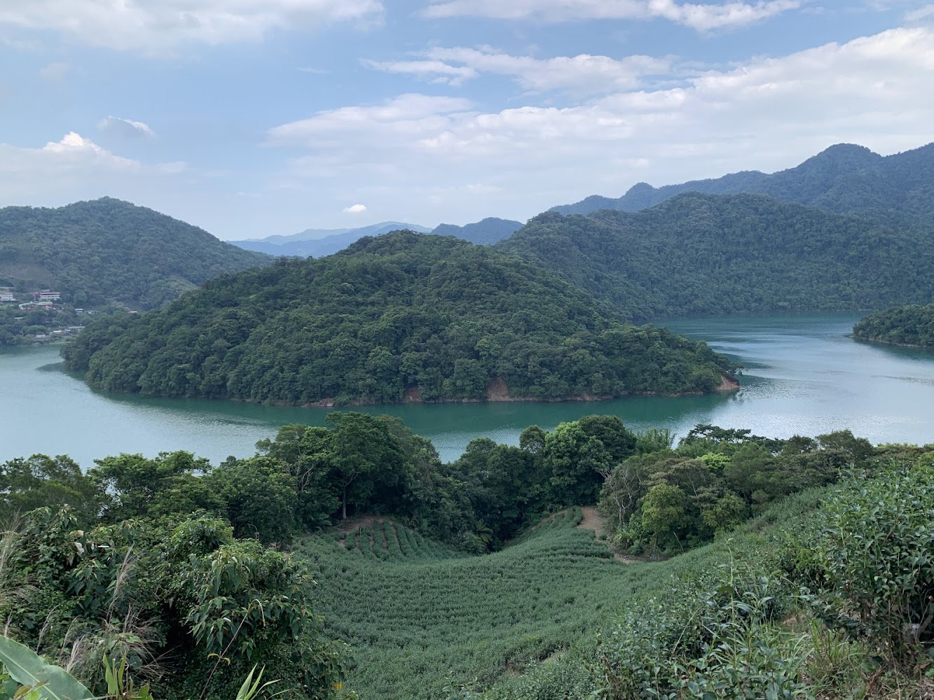 青翠山林環繞碧綠湖泊的失落的村莊景觀