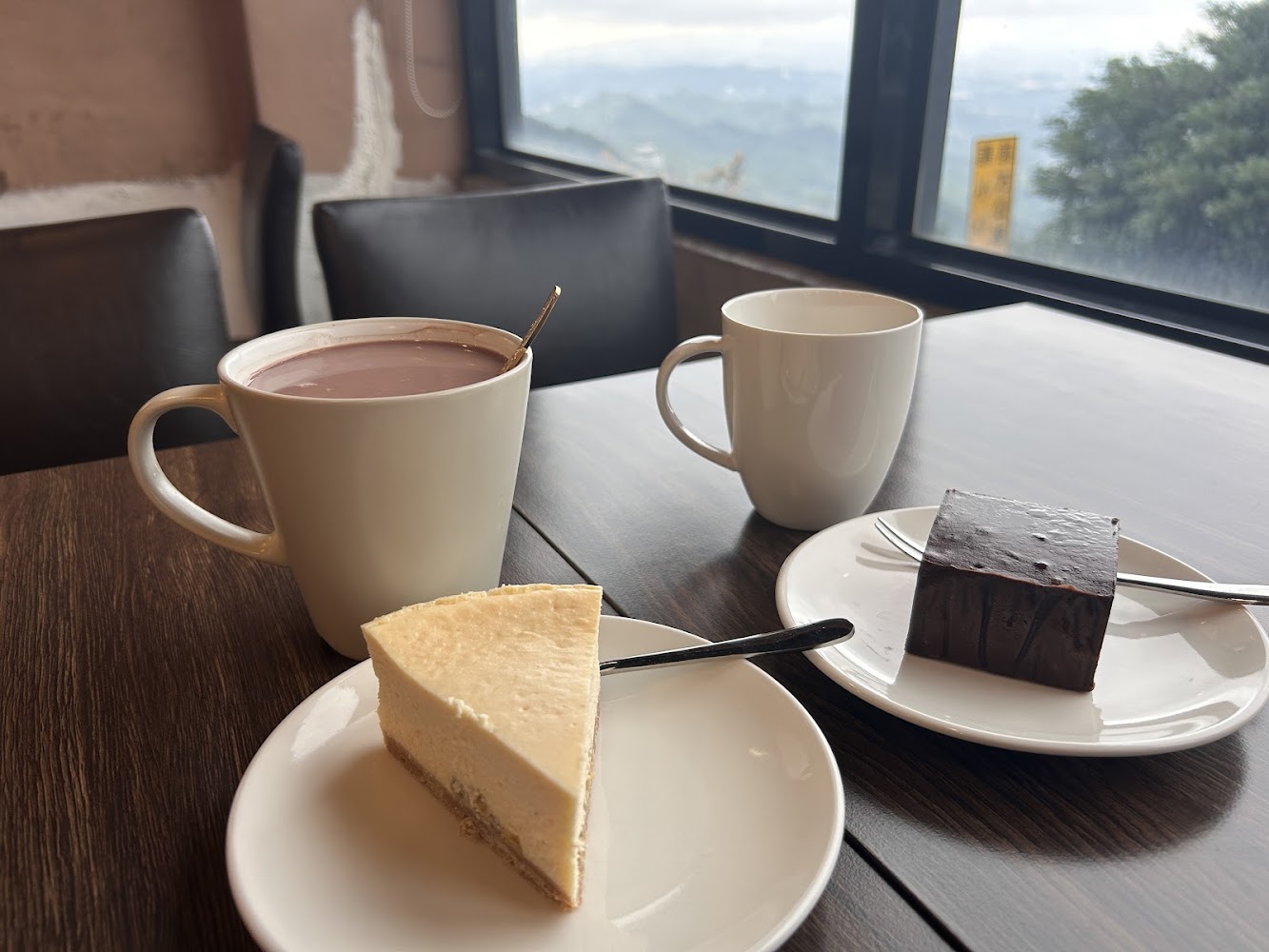 熱飲與兩塊蛋糕擺在木桌上