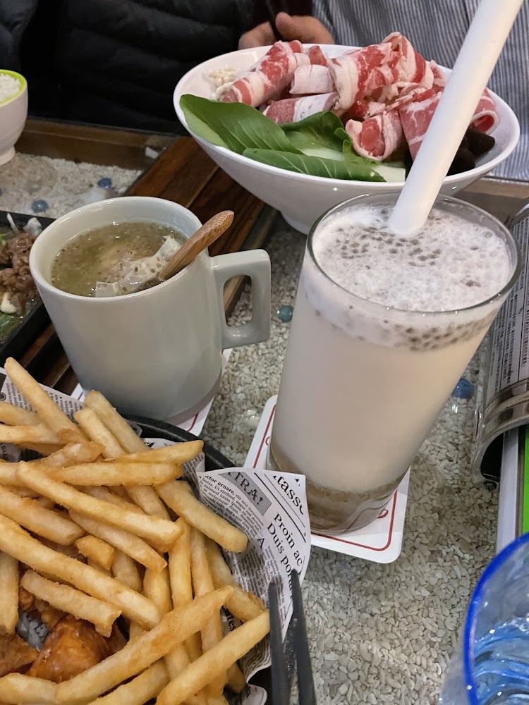 火鍋料搭薯條飲料與熱湯的豐盛餐桌