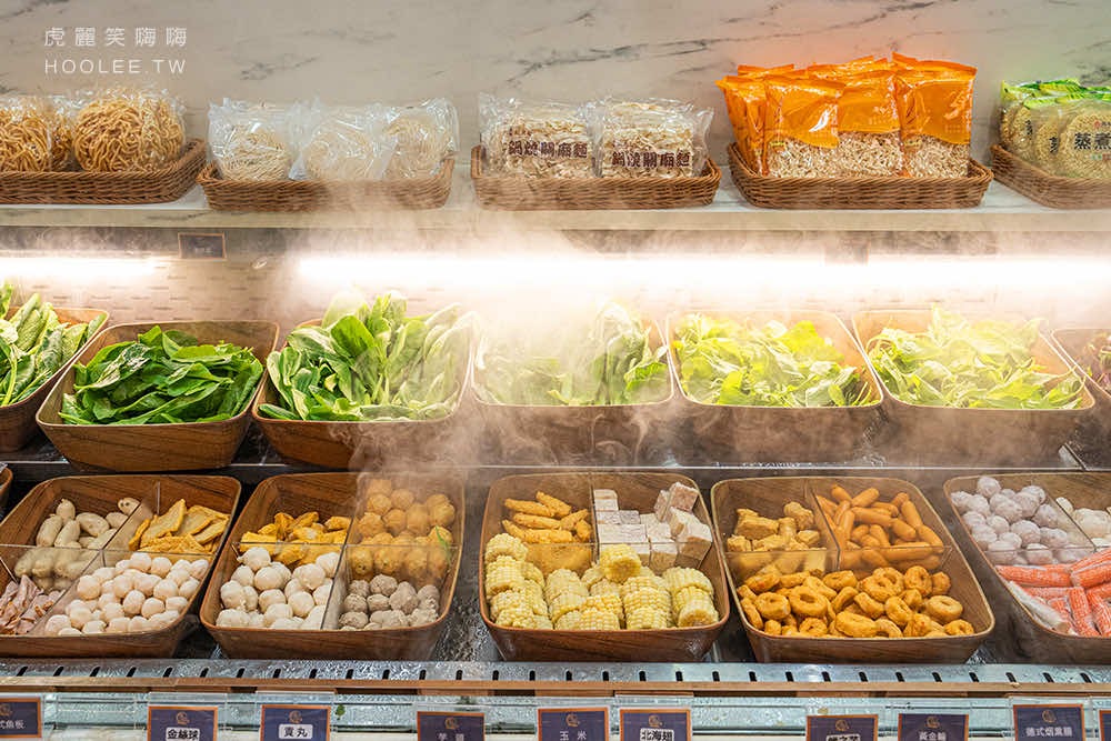 火鍋店內自助食材區，有蔬菜、玉米、豆腐、丸子與麵條。