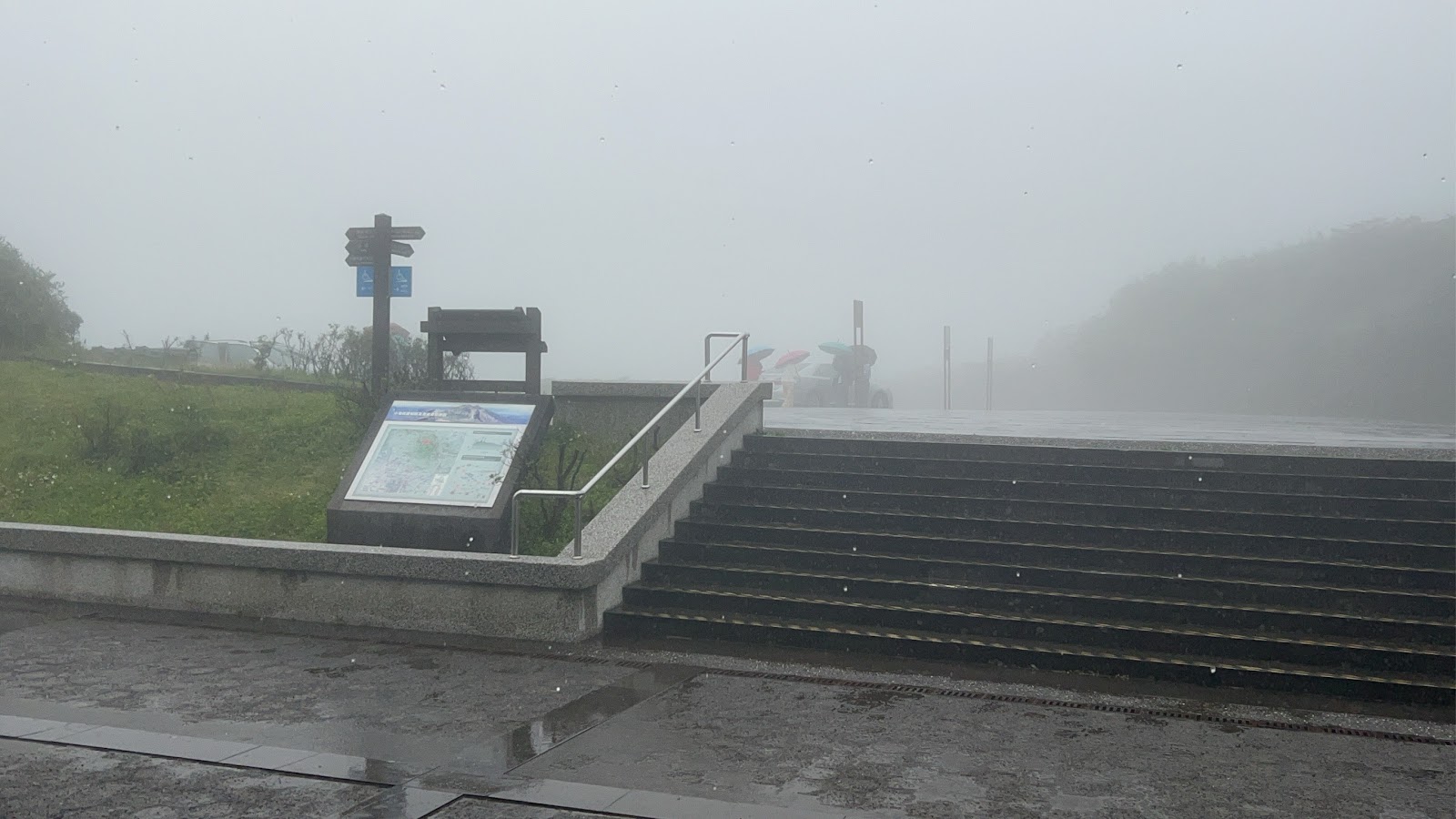 小油坑遊憩區入口步道霧雨天，石階和路標清晰可見