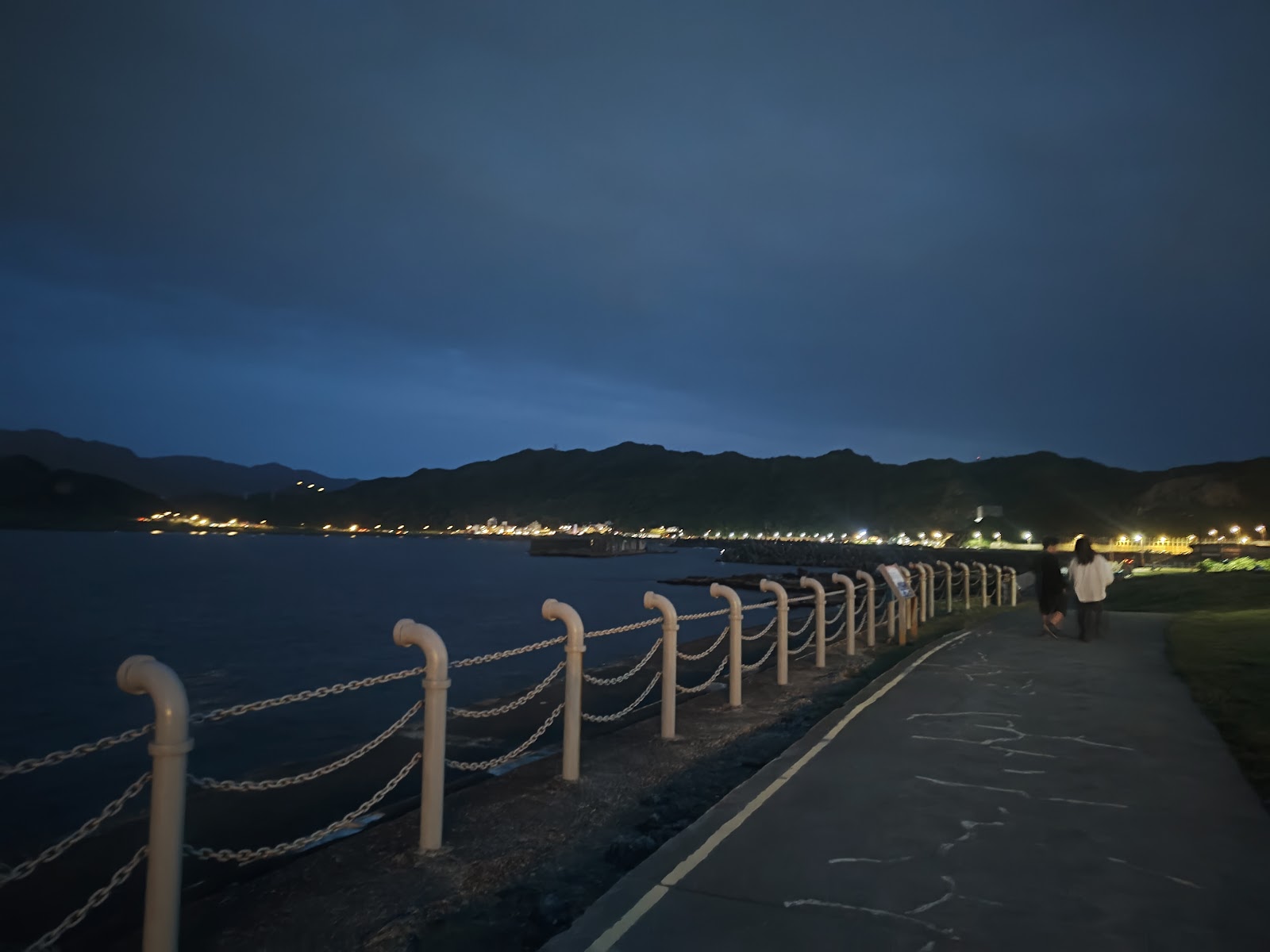 潮境公園夜晚步道鐵鍊欄杆遠方燈光山脈輪廓