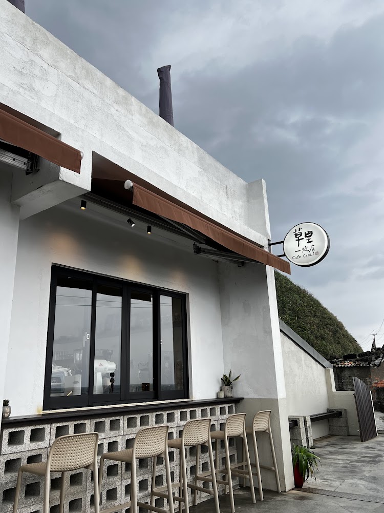 白色外牆的草里一號店外觀與店外吧台座位