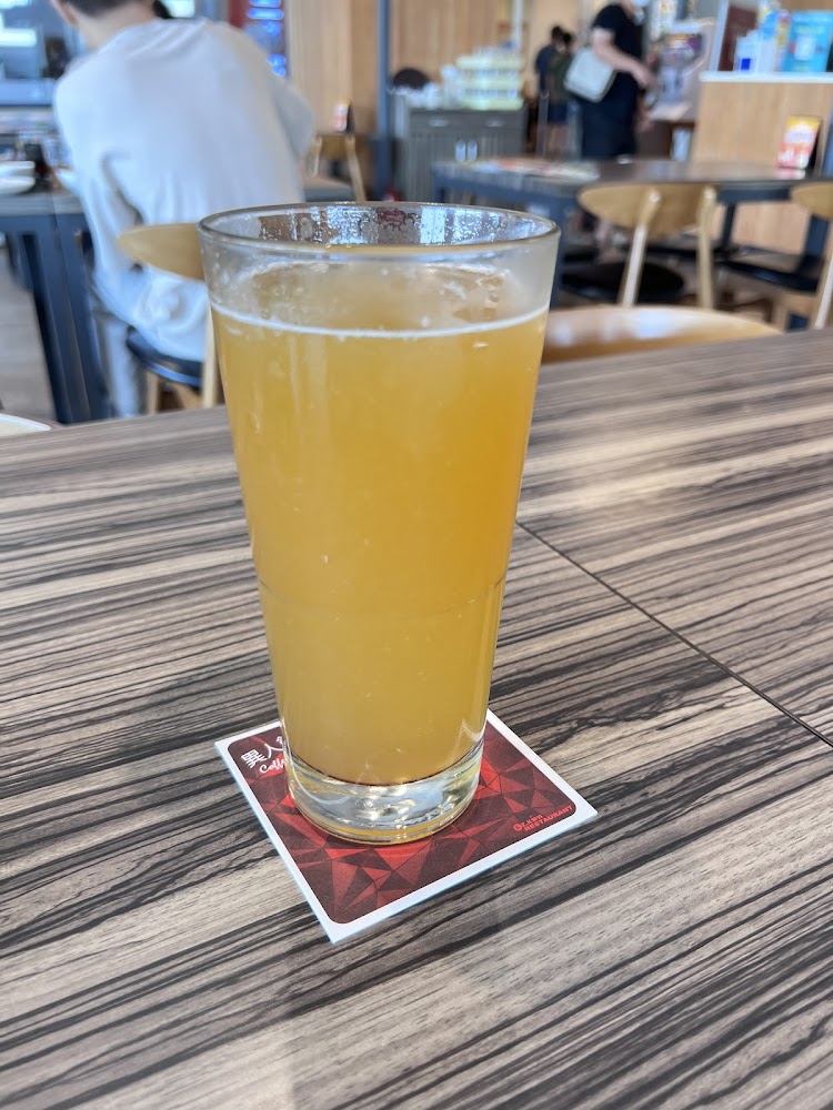 一杯橘黃色飲料的玻璃杯，放在餐桌上