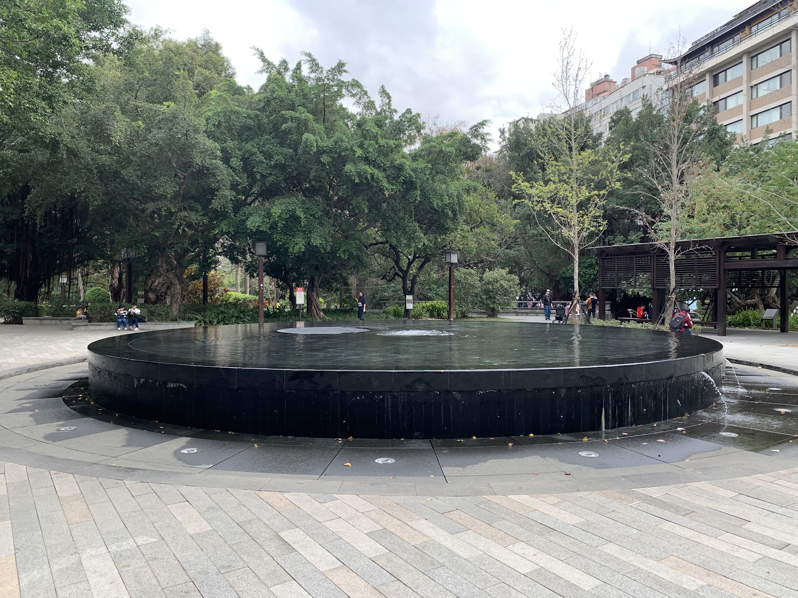北投公園噴水池廣場，遊客悠閒漫步，百年公園的從容氣質