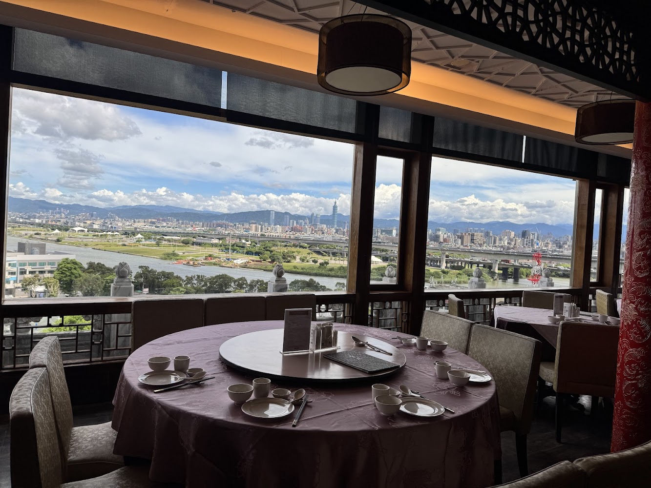餐廳圓桌搭配大片窗景可見城市與藍天