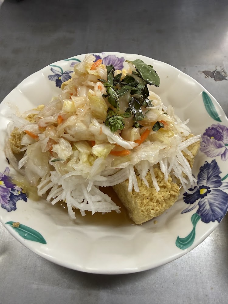 經典臭豆腐搭配泡菜白蘿蔔絲與九層塔，擺在花紋瓷盤中