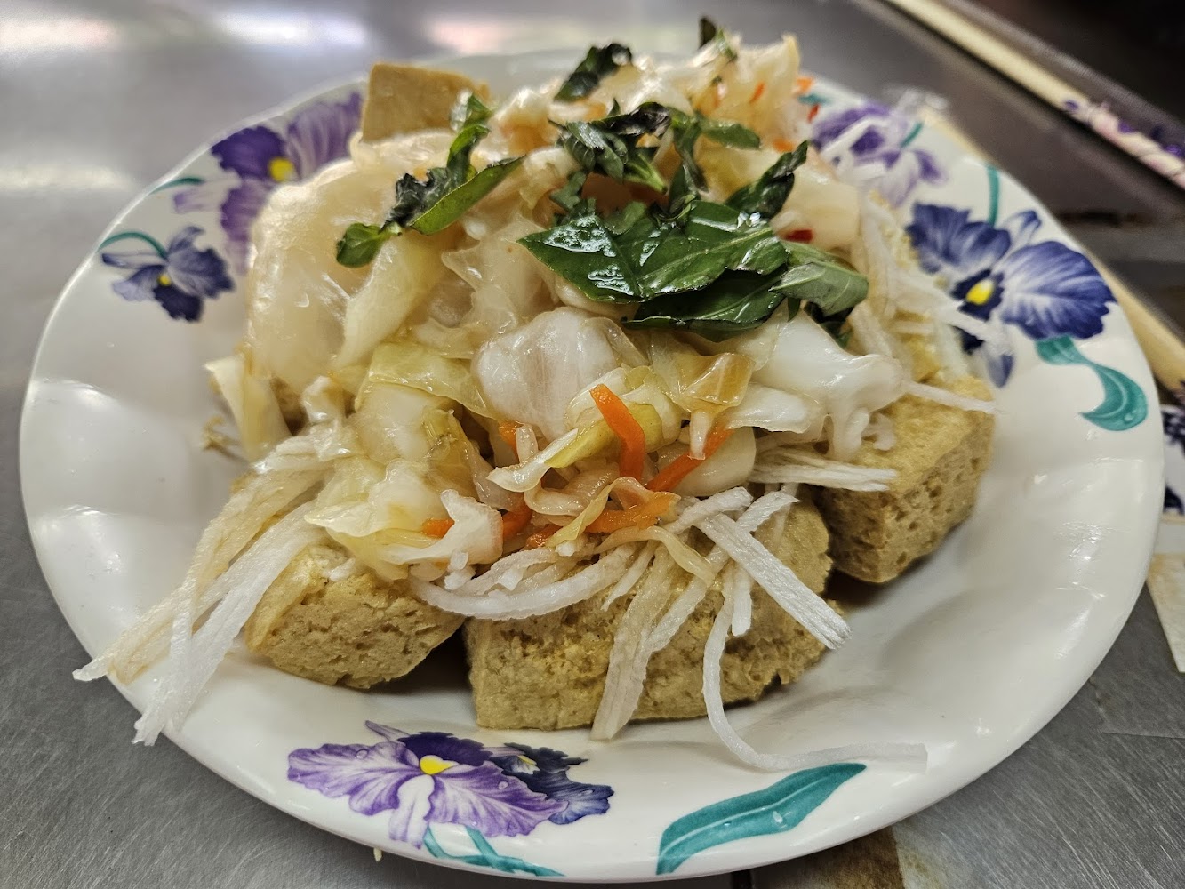 臭豆腐上鋪滿泡菜與紅蘿蔔絲，外酥內軟
