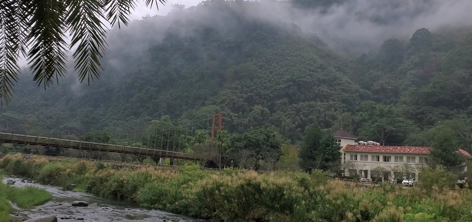 雲霧山景、河流與園區建築的廣角景觀