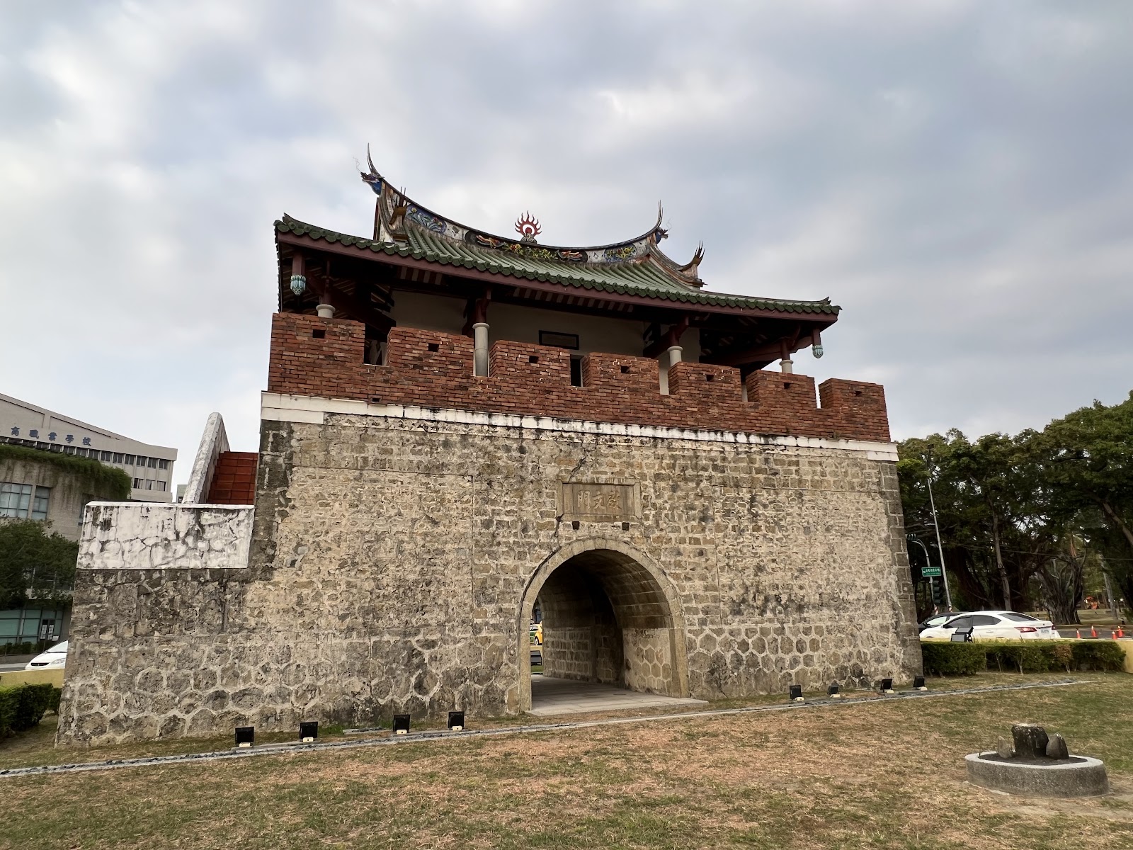 高雄左營舊城城牆遺跡遠景,殘破咕咾石牆在荒草中延伸,呈現歷史滄桑感