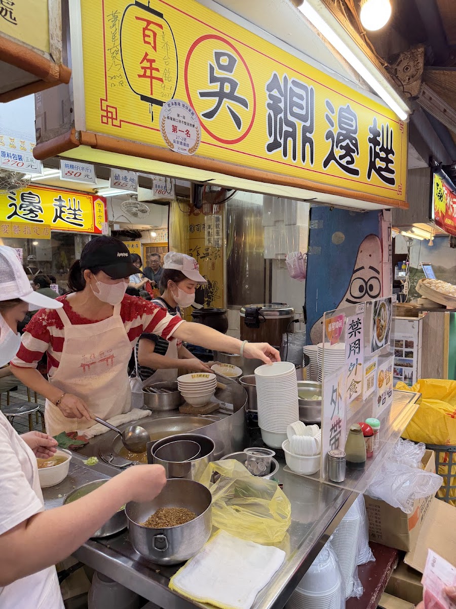基隆廟口夜市百年吳鍋邊趣攤位，工作人員忙碌烹煮傳統美食
