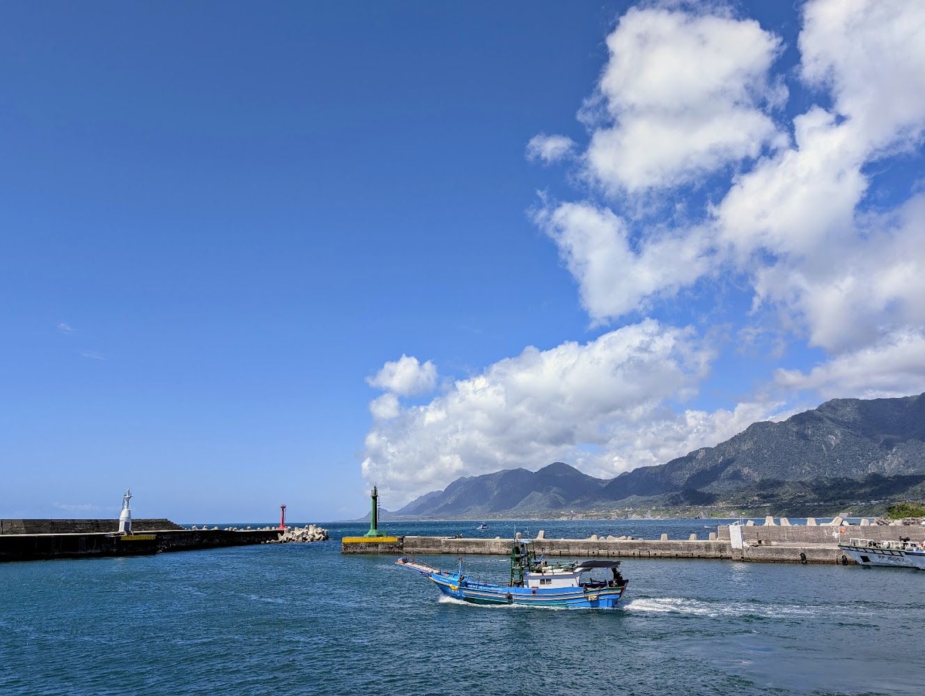 成功漁港藍白色漁船與燈塔風景，海面平靜