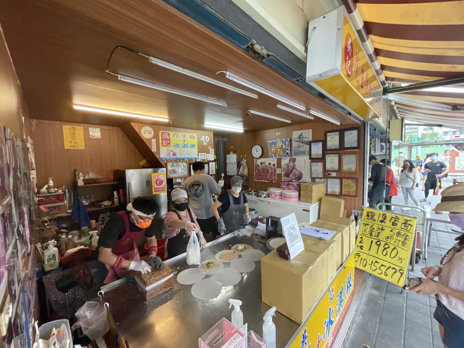 吳記花生捲冰淇淋店內全景，工作人員製作中，店外可見排隊人潮