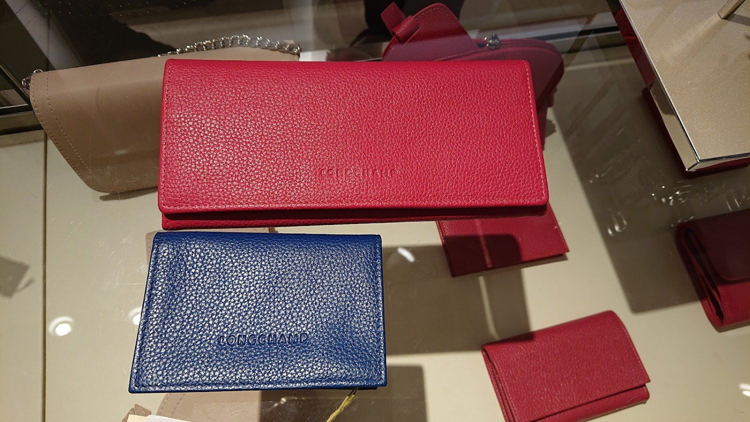 Longchamp 台中三民店展示紅色長夾與藍色卡夾等皮件