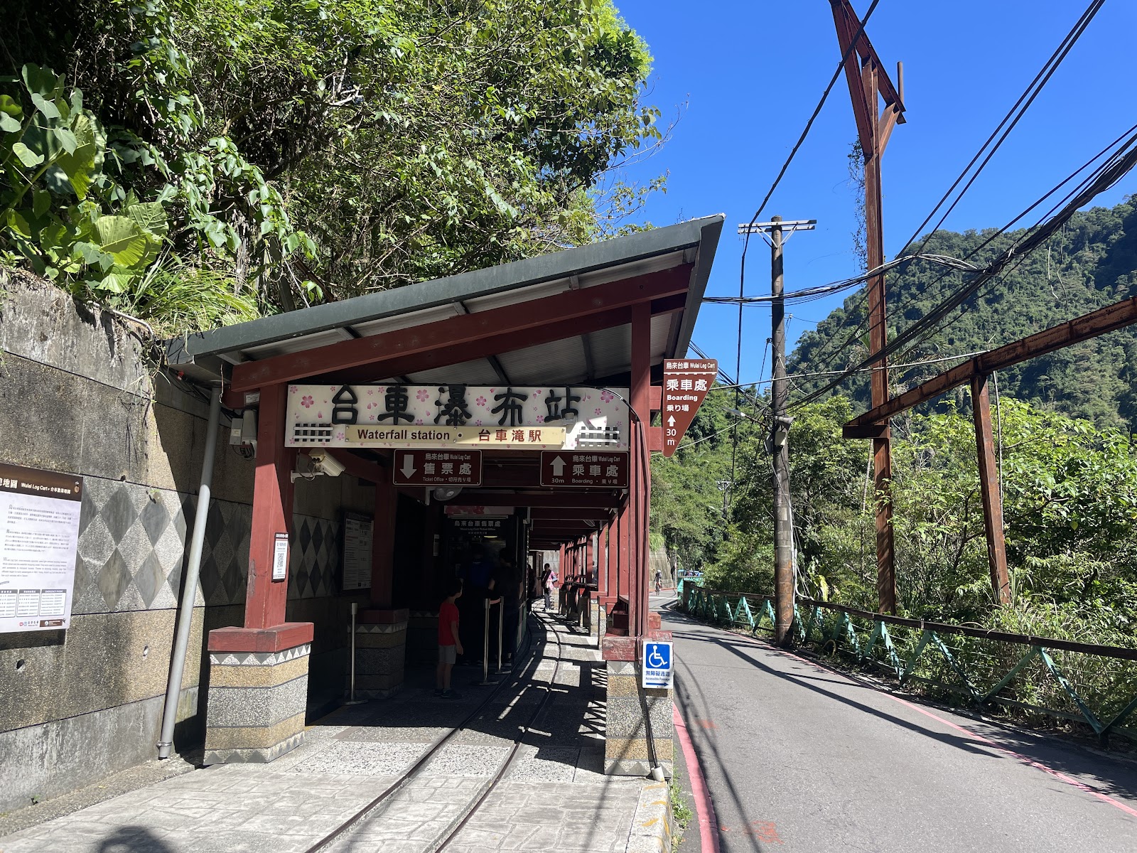 烏來台車瀑布站入口，紅色木構建築，背景翠綠山林