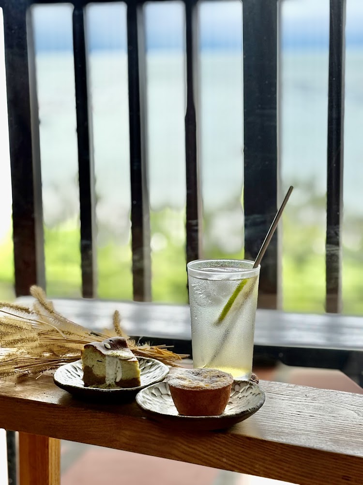 冷飲與甜點擺在木桌上背後是自然景色