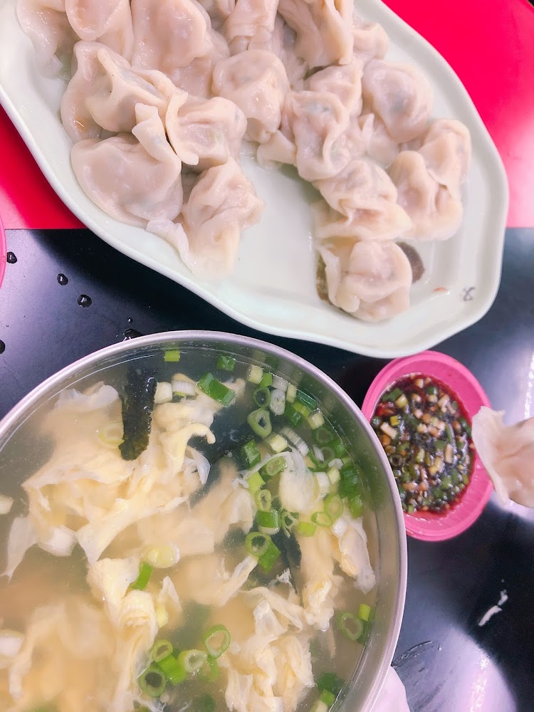 一盤水餃搭配一碗蛋花湯和醬料
